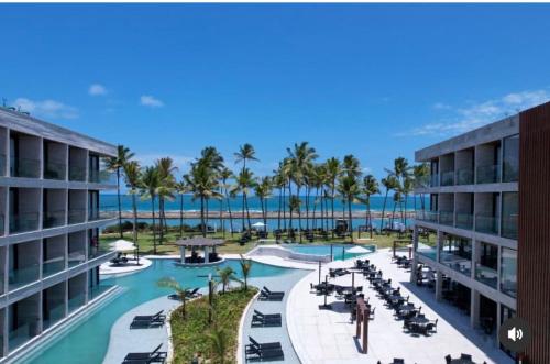 a view of a resort with a pool and palm trees at Porto Alto Resort Muro Alto B02-215 - 224 in Ipojuca