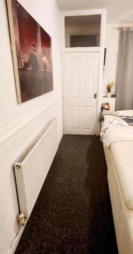 a room with two beds and a white door at Luxury King-size Rm in Bolton