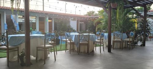 a group of tables and chairs with blue table cloth at Posada Casa Bonita in Puerto Maldonado