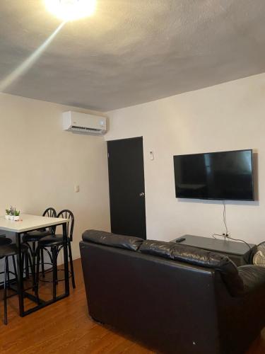 a living room with a black couch and a table at Departamento acogedor segundo piso 2 recamaras in Monterrey
