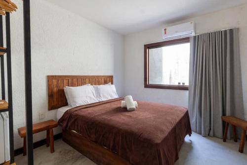 a bedroom with a bed with a teddy bear on it at Casa com Piscina 20 metros do mar - Milagres in Passo de Camarajibe