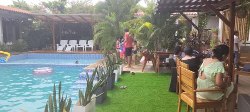 a group of people sitting around a swimming pool at Posada Casa Bonita in Puerto Maldonado