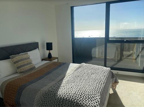 ジーロングにあるMERCER APARTMENTS 2 Bedroom Apartment with Bay Views on the Geelong Waterfront - 711の海の見えるベッドのある寝室