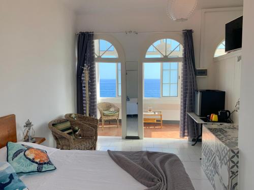 a bedroom with a bed and a view of the ocean at Vitorina Corte Guesthouse in Funchal