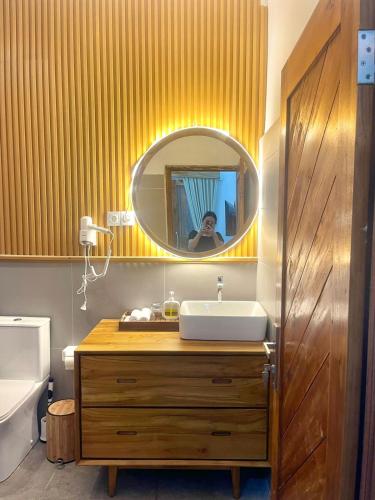 a person taking a picture of a bathroom with a sink at Layana One in Klungkung