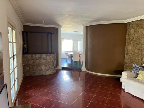 un salon avec un canapé et un mur en pierre dans l'établissement Casa na região dos lagos, à São Pedro da Aldeia