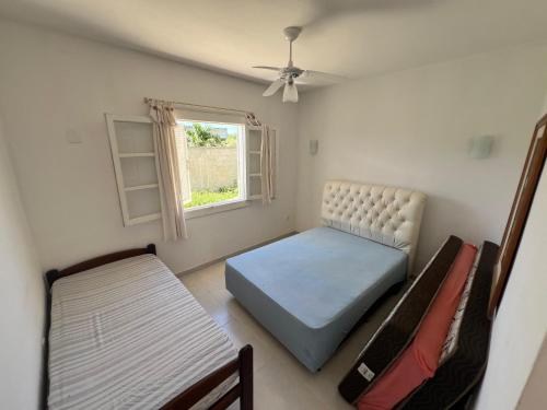 une chambre avec un lit, une chaise et une fenêtre dans l'établissement Casa na região dos lagos, à São Pedro da Aldeia