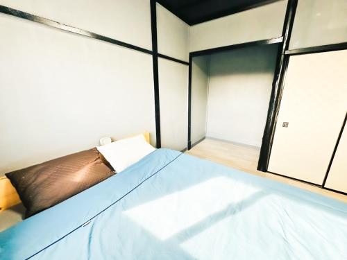a bedroom with a bed and a window at まるとくハウス和歌山 in Wakayama