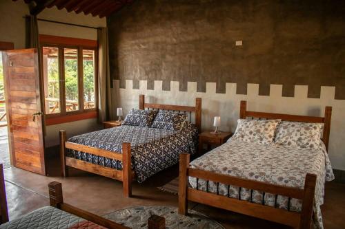 a bedroom with two beds and a window at Casa Club El Pueblo Simbal in Trujillo