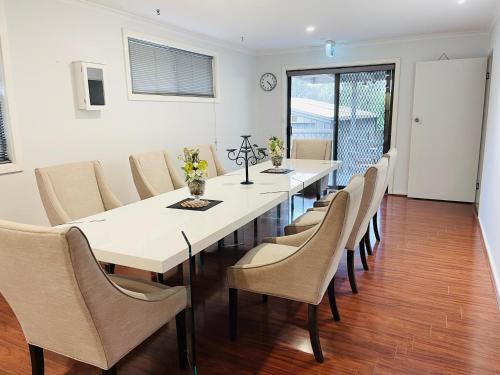 a dining room with a white table and chairs at D130 The Link Fantasy Place in Keilor