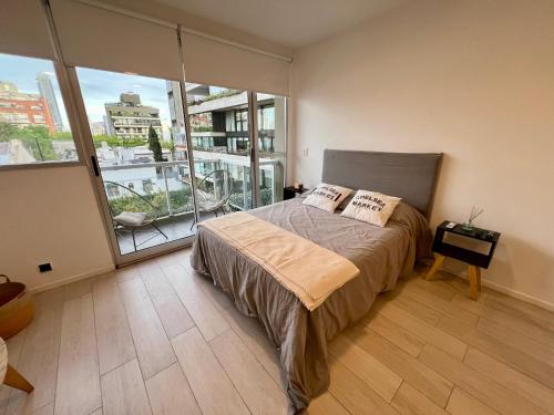 a bedroom with a bed and a large window at Arevalito Monoambiente in Buenos Aires