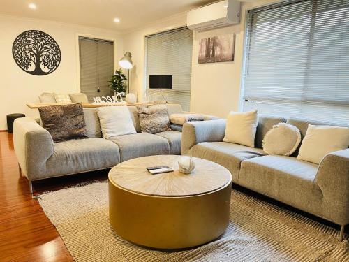 a living room with couches and a coffee table at D130 The Link Fantasy Place in Keilor