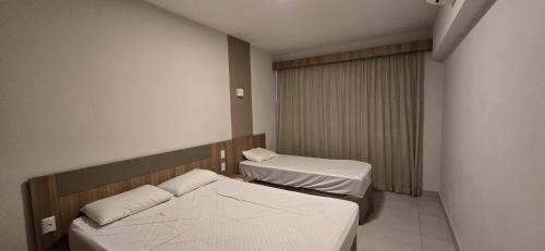 a small room with two beds and a window at Praias do Lago Eco Resort - Central de Reservas in Caldas Novas