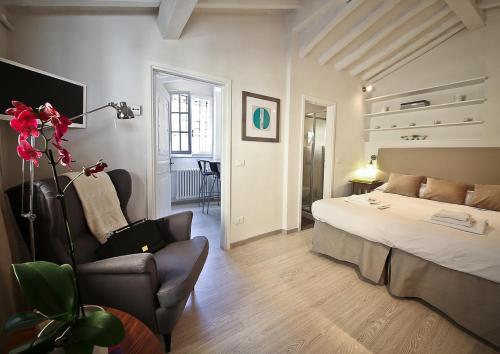 フィレンツェにあるApartments Florence Pinzochere Mansardaのベッドルーム1室(ベッド1台、椅子付)