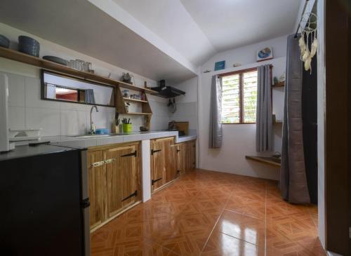 a kitchen with wooden cabinets and a sink and a window at Bungalow in El Nido
