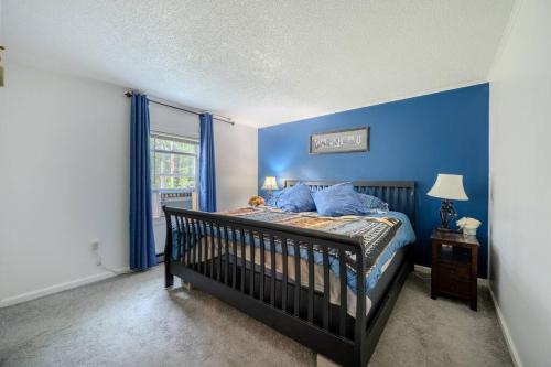 a bedroom with a crib and blue walls at Belmont Lakeside Retreat in Belmont