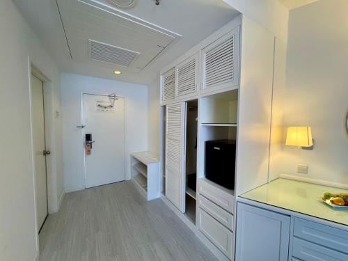 a white kitchen with white cabinets and a television at ROYAL PARK HOTEL @ UNITEN in Kajang