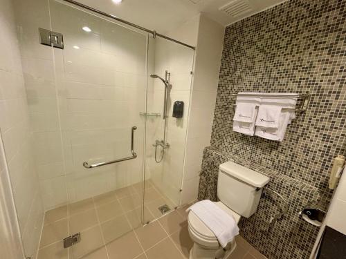 a bathroom with a toilet and a glass shower at ROYAL PARK HOTEL @ UNITEN in Kajang