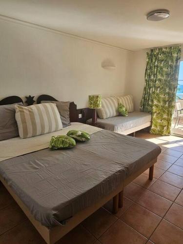 a living room with a couch and a table at studio La Cocoteraie, vue mer in Courcelles Sucrerie