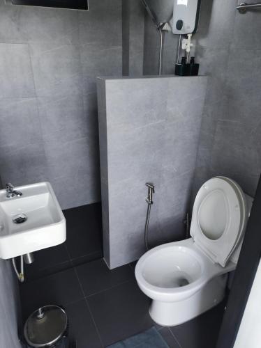 a bathroom with a white toilet and a sink at De'La Moon เดอ ลา มูน in Ban Klaeng Bon