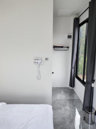 a bedroom with a bed and a window at De'La Moon เดอ ลา มูน in Ban Klaeng Bon