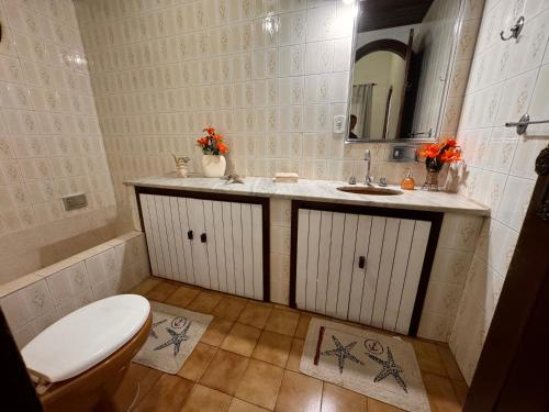 a bathroom with a toilet and a sink and a mirror at Pousada Casa de Buzios in Búzios