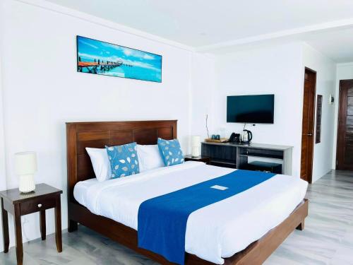 a bedroom with a large bed and a television at Porto Novo Anilao Dive and Leisure Resort in Mabini