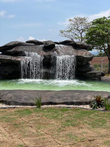 a waterfall in the middle of a park at Pousada Pôr do Sol in São João Batista do Glória