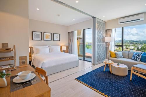 a bedroom with a bed and a living room at Laguna Lakeside Residences by Banyan Living in Bang Tao Beach