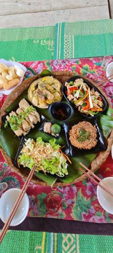 a tray of food on a table with plates of food at Ba Be Retreat in Bak Kan
