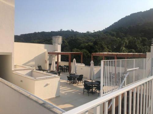 a balcony with chairs and umbrellas on a building at Apartamento aconchegante na Praia in Ubatuba