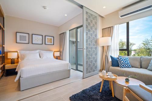 une chambre avec un lit et un canapé dans l'établissement Laguna Lakeside Residences by Banyan Living, à Laguna Phuket
