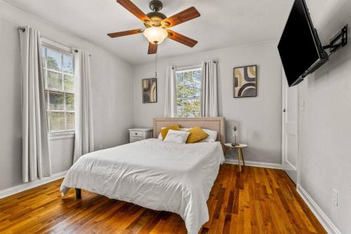 a bedroom with a bed and a ceiling fan at East Hill Manor with 2 Kitchens Near Beach & Downtwn in Pensacola