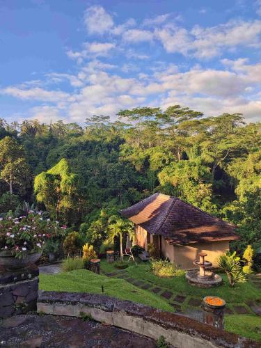 a house in a garden with trees in the background at Bagus Jati Health & Wellbeing Retreat in Tegalalang