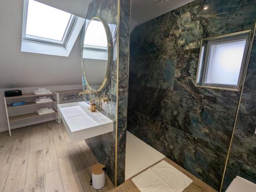 une salle de bain avec un lavabo et un miroir dans l'établissement Gîte élégant avec SPA, réception et accessibilité PMR près de Paris - FR-1-590-442, à Lorcy