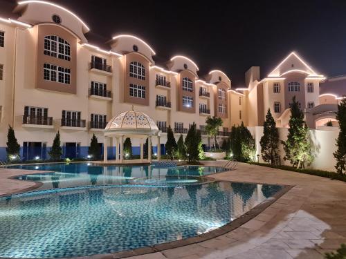 a large building with a swimming pool at night at Legend Valley Hotel Ha Nam in Phủ Lý
