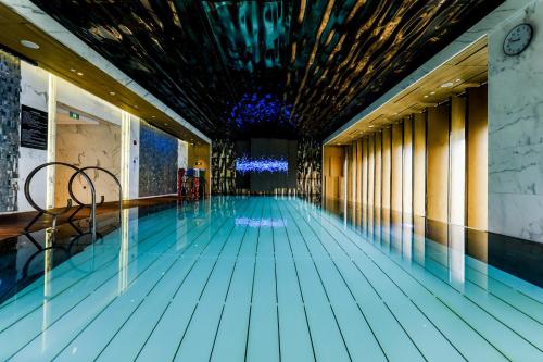 a swimming pool with a blue floor and a ceiling at The St. Regis on the Bund, Shanghai in Shanghai