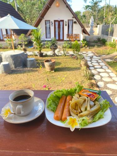 a table with a plate of food and a cup of coffee at Maskot Penida Cottage in Nusa Penida