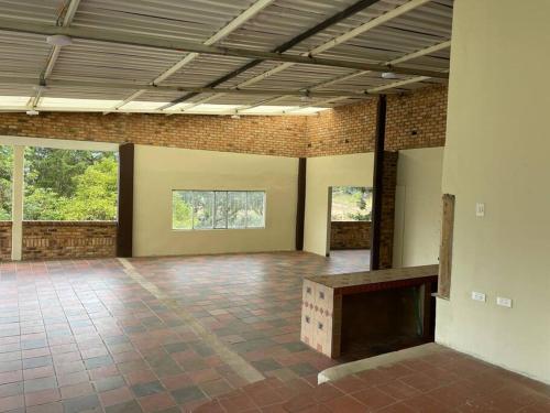 a large empty room with a brick wall and a table at Finca La Esperanza in Nobsa