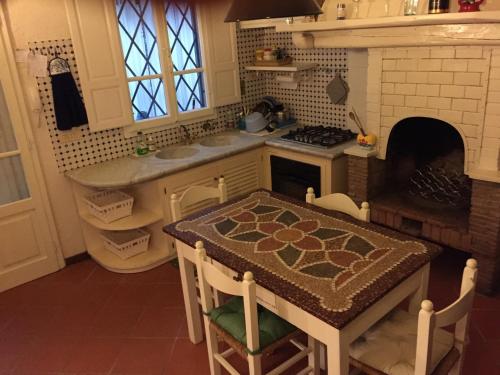 kuchnia ze stołem, kuchenką i kominkiem w obiekcie Il Nido sul mare a Forte dei Marmi w mieście Forte dei Marmi