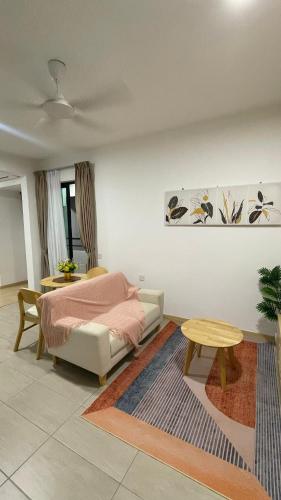 a living room with a bed and a table at Mutiara Melaka Beach Resort in Kampong Pantai Dusun