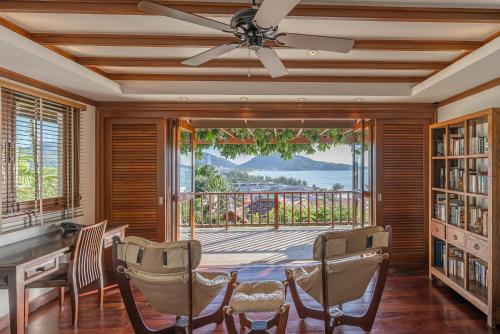 a dining room with a ceiling fan and a table and chairs at Villa Suriya B2 in Patong Beach