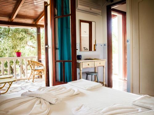 a bedroom with a bed and a balcony at Areti Orfeas Studios in Vasilikos