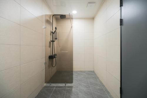 a shower stall with a glass door in a bathroom at Hwaseong Stay13 Hotel in Hwaseong