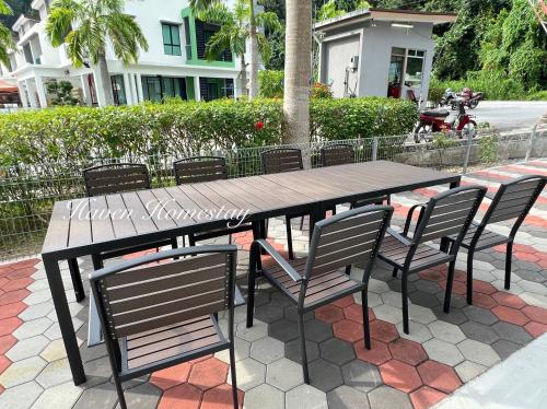 a wooden table and chairs on a patio at Haven Homestay晶晶屋 (Brand New Homestay!) in Kampong Sungai Udang