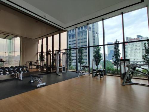 a gym with large windows and a large room with tread machines at Luxury Apt close to KLCC Aria in Kuala Lumpur