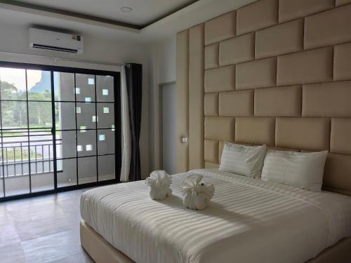 two stuffed animals sitting on a bed in a bedroom at Kiree River Hotel โรงแรมคิรีริเวอร์ in Ban Thong Pha Phum
