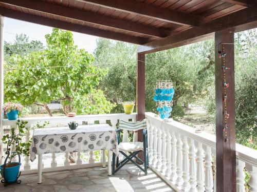 a white porch with a table on a white railing at Areti Orfeas Studios in Vasilikos