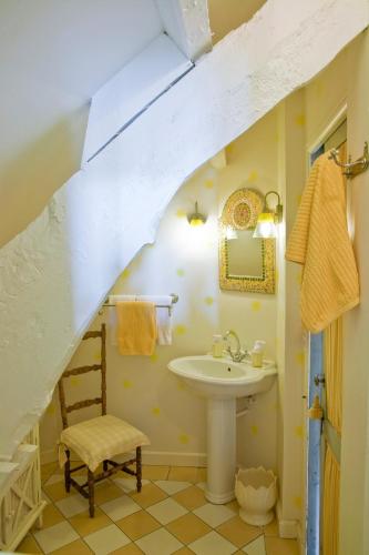 La salle de bains est pourvue d'un lavabo et d'une chaise. dans l'établissement Maison d'Hôtes La Guérandière, à Guérande