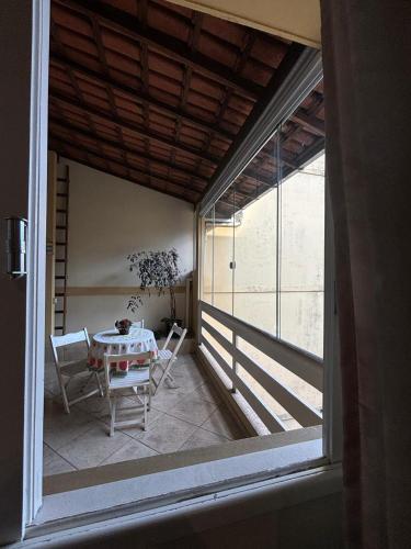 a room with a table and chairs on a balcony at Casarão DM in Domingos Martins